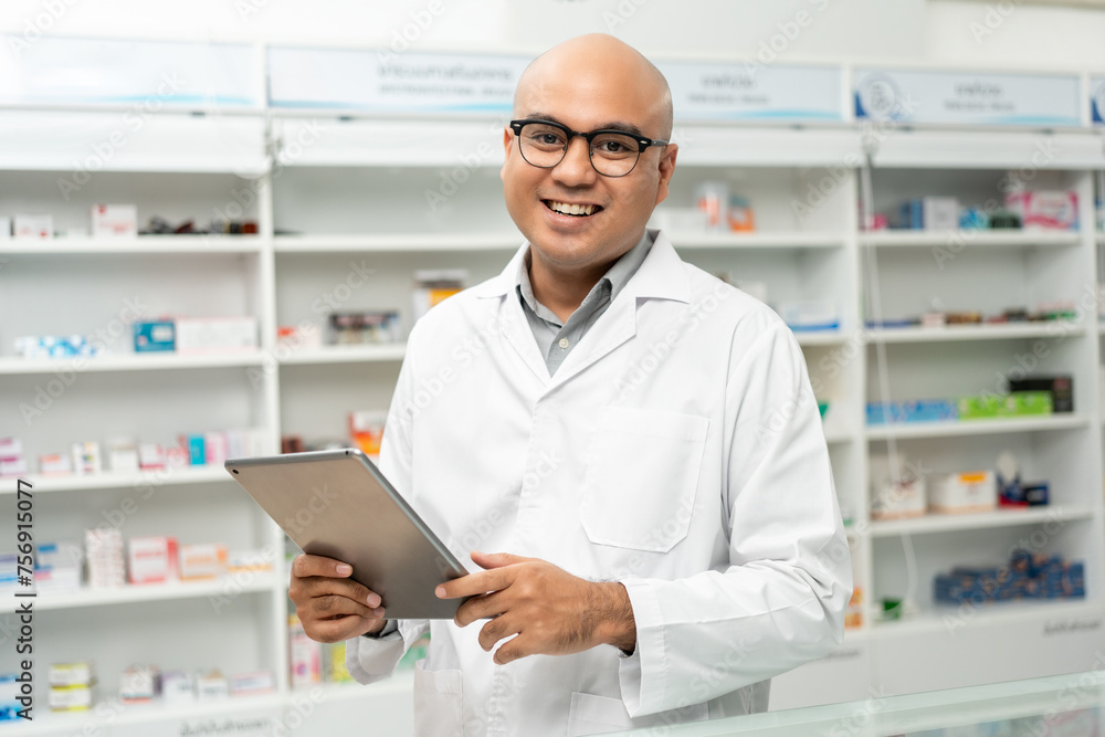 Professional asian man pharmacist checks inventory arrangement of medicine in pharmacy drugstore. Male Pharmacist wearing uniform standing near drugs shelves counter prescription to customers Professional asian man pharmacist checks inventory arrangement of medicine in pharmacy drugstore. Male Pharmacist wearing uniform standing near drugs shelves counter prescription to customers