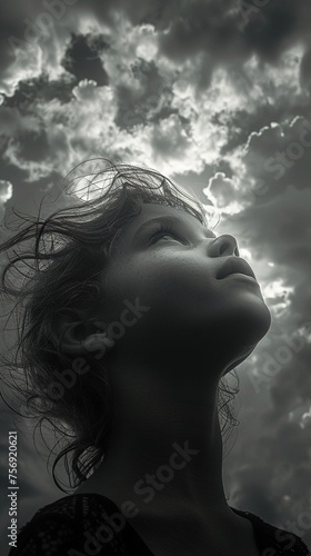 Child girl looking up, moody overcast sky.  Emotional storytelling in photography. AI Generated. © Mariana