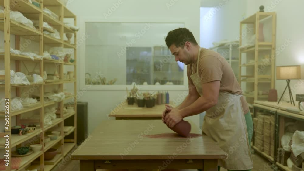 Pottery artist preparing raw brown clay lump shaping material in workshop Pottery artist preparing raw brown clay lump shaping material in workshop