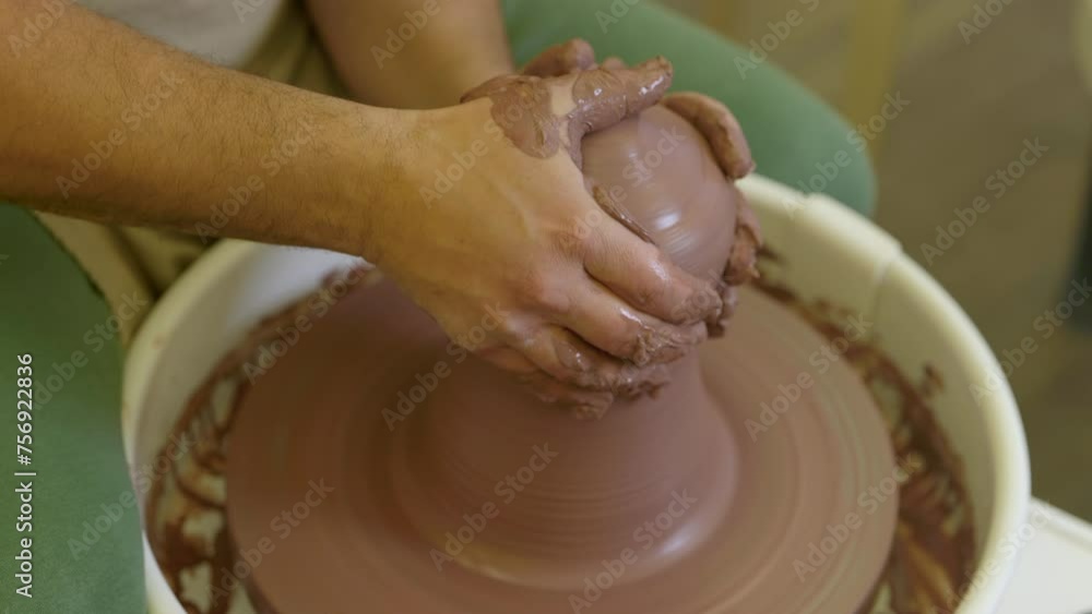Creative potter forming handmade wet clay vase vessel spinning on workshop pottery wheel Creative potter forming handmade wet clay vase vessel spinning on workshop pottery wheel
