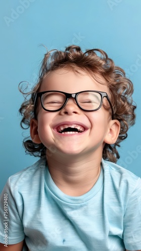 Portrait of a smiling little boy with glasses on a blue background