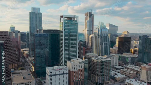 Drone flyover Austin Texas iconic downtown tower district overlooking Frost Bank Tower, The Austonian, JW Marriot Hotel, and the Westin in a beautiful golden sunset with clouds. photo