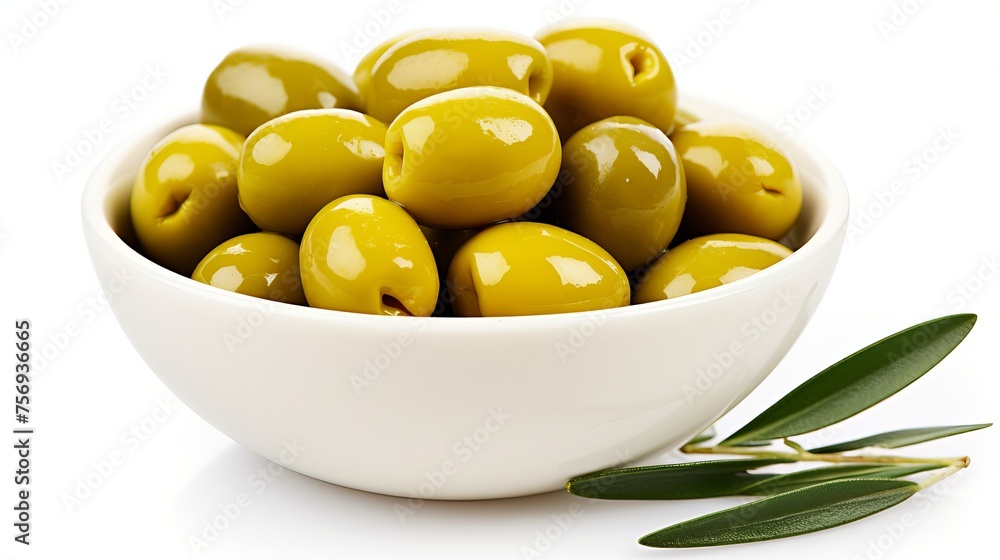 Bowl of pickled green olives alongside an olive tree branch, both placed on a white background. Bowl of pickled green olives alongside an olive tree branch, both placed on a white background.