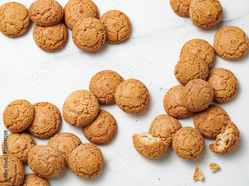 pile of cookie amaretti on white marble background - traditional Italian Sardinian pastry. Delicious amaretti biscuit cookies made from almond or apricot kernels with copy space