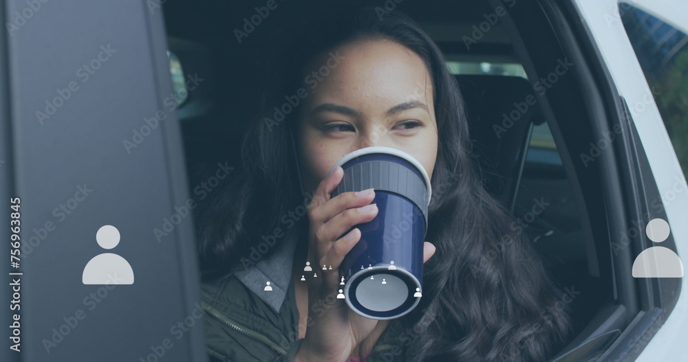Fototapeta premium Young biracial woman sipping from a cup in a car