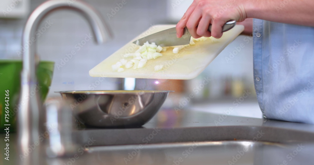 Image of light over midsection of man cooking using knife and chopping board in kitchen