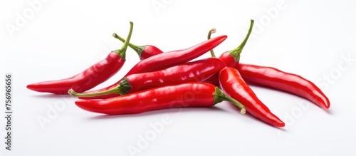 A stack of vibrant Birds eye chilis, Chile de rbol, Cayenne peppers, and Peperoncini on a plain white backdrop, showcasing the diverse use of chili peppers in food as a staple ingredient and spice photo