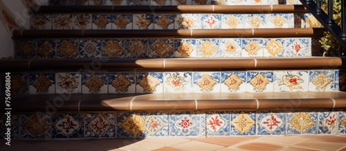 A close up of a set of hardwood stairs with a patterned tile design  showcasing the beautiful wood stain and intricate metal detailing