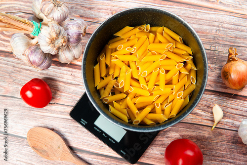 Preparing healthy and nutritious pasta. Weighing pasta on a kitchen scale, counting calories and checking macronutrients. Healthy Mediterranean diet