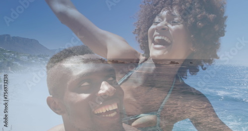 Image of happy african american couple having fun at beach over sea