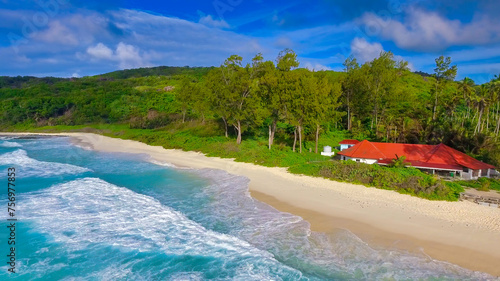 Grand Anse Beach in La Digue, Seychelles. Aerial view of red house along the coast