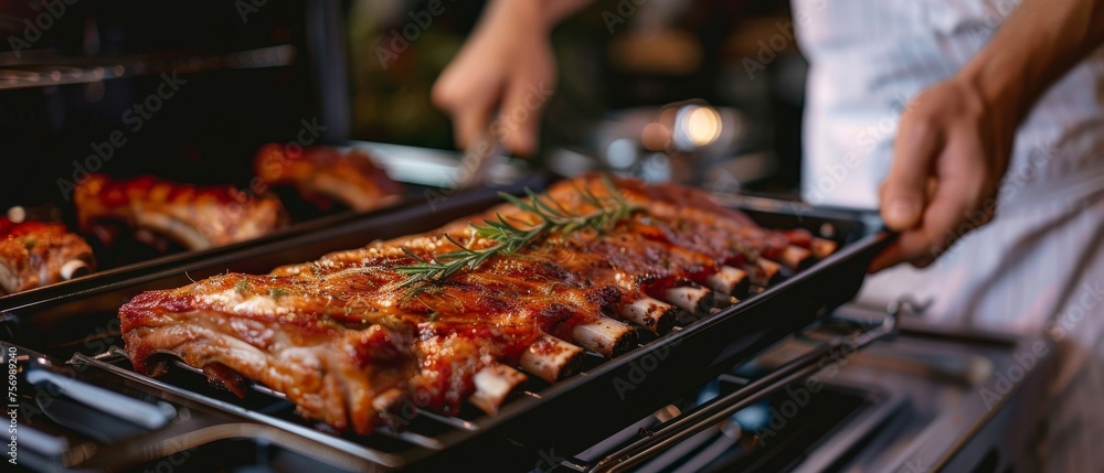 Chef removing pan of roasted ribs from oven closeup