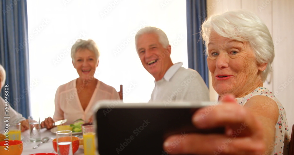 Senior friends enjoy a meal together at home Senior friends enjoy a meal together at home