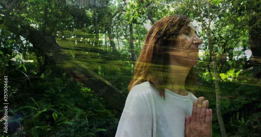 Close up of a Caucasian woman mediating outdoors amongst the trees Close up of a Caucasian woman mediating outdoors amongst the trees