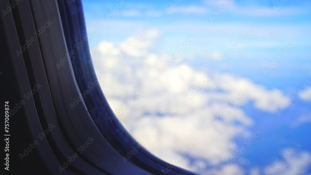 View of blur sky with white clouds through airplane window. View of blur sky with white clouds through airplane window.