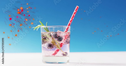 Image of confetti falling and cocktail on blue background