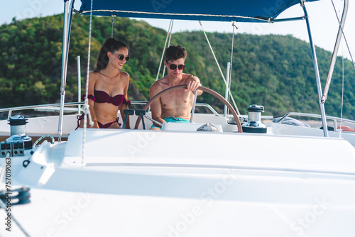 A couple is sitting on a boat in the ocean © chokniti