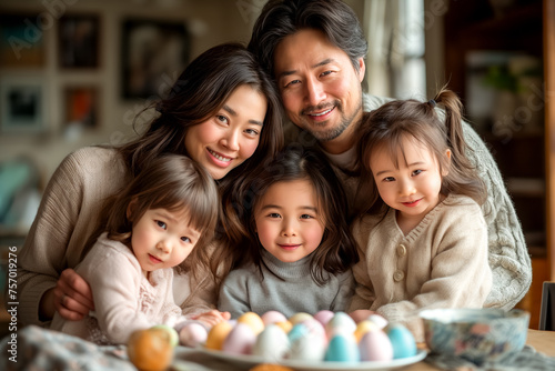 cute Asian family painting Easter eggs at home. kids and parents prepare for Easter © zamuruev