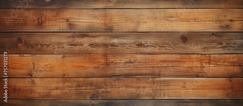 A closeup photo featuring a brown wooden wall with amber tints and shades. The hardwood plank flooring is coated in wood stain and varnish, creating a beautiful rectangle pattern