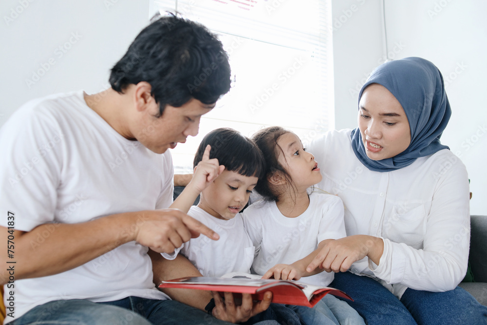 Happy Asian Family Spending Time Together Reading Book at Home Happy Asian Family Spending Time Together Reading Book at Home