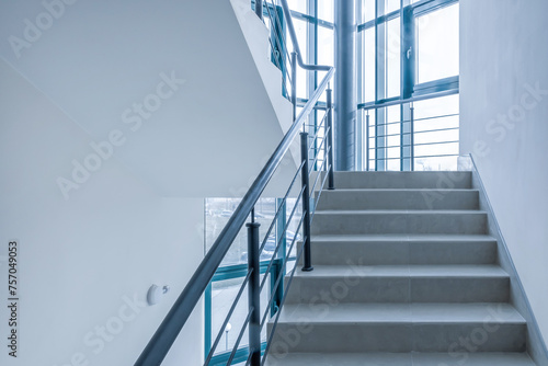 stairs emergency and evacuation exit stair in up ladder in a new office building in blue color grading toning