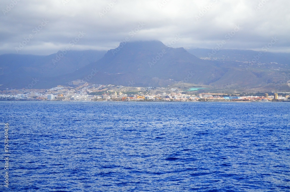 View on resorts and beaches of South coast of Tenerife island during sail boat trip along coastline, Canary islands, Spain in winter