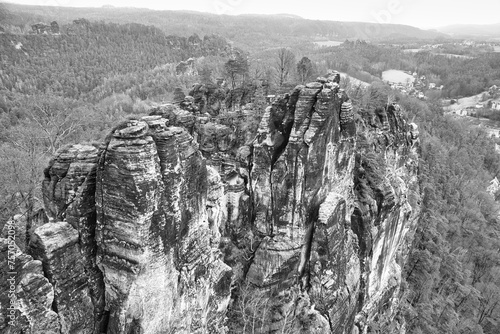 Jagged rocks at the Basteibridge. Wide view over trees and mountains. National park photo