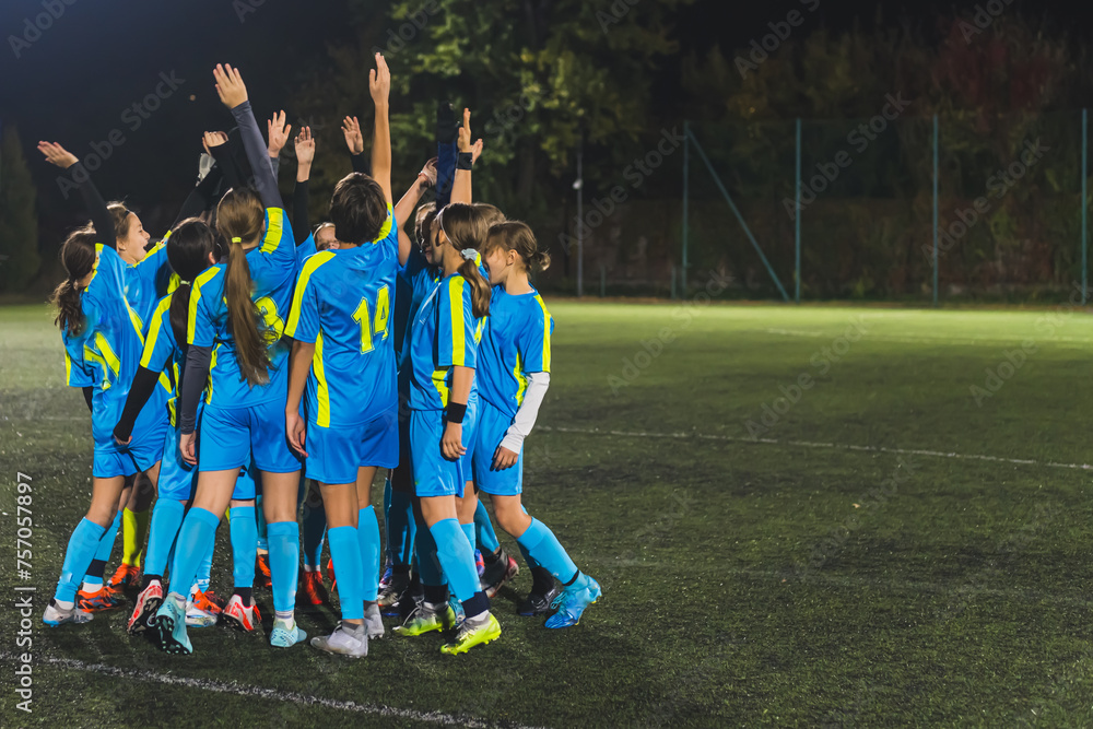 Obraz premium full shot of school girls football team getting ready with a coach for the match, soccer team concept. High quality photo