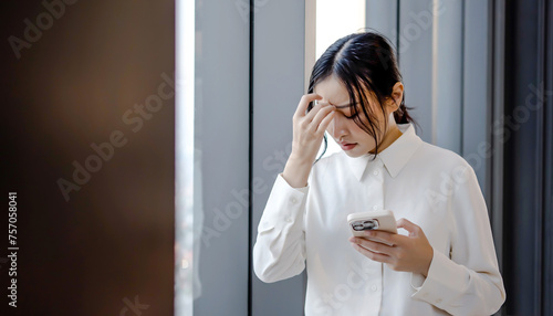 Upset stressed asian woman holding cellphone disgusted with message she received in office, Sad looking face expression emotion feeling reaction perception body language, Dissatisfied, confusingly