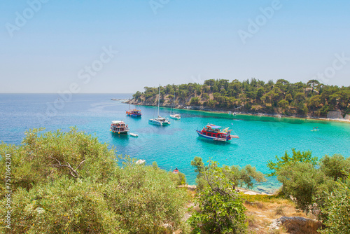 Tourist boats sail through the serene blue lagoon on a sunny day on summer vacation.