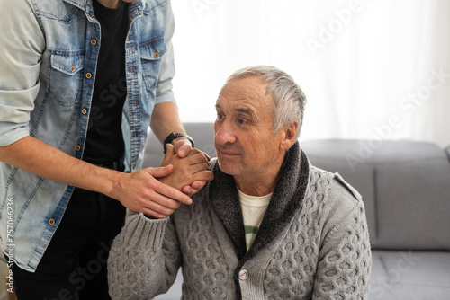 Grown up son asking for apologizes to offended stressed elderly senior daddy, sitting together on couch. Compassionate young man supporting, giving psychological help to frustrated middle aged father. photo