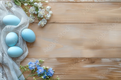 Easter background with blue eggs and spring flowers on a wooden table in a flat lay top view, space for text