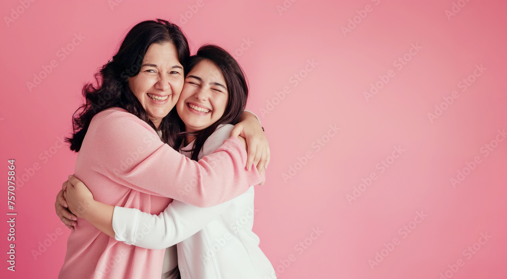 Happy Mothers Day banner background with a mom and her teenage daughter hugging and laughing in front of a pink background with copy space Happy Mothers Day banner background with a mom and her teenage daughter hugging and laughing in front of a pink background with copy space