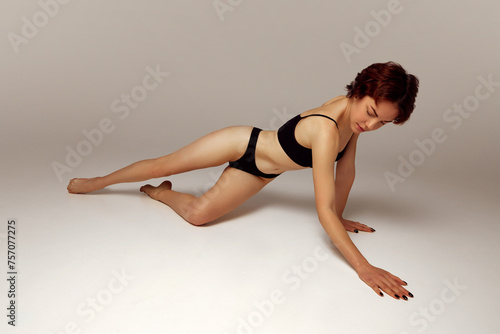 Sensual, beautiful young woman with slim body posing in underwear against beige studio background. Concept of female health care, sexuality, passion and pleasure, wellness