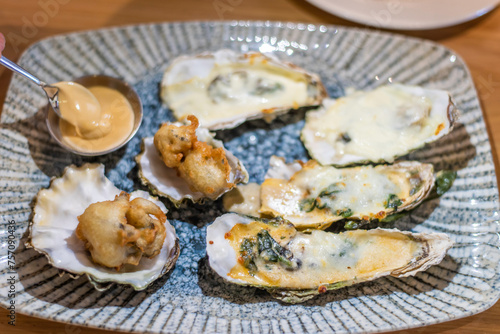 Plate with baked oysters on a table in a restaurant