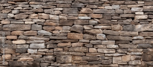 A closeup of a brown stone wall with a lot of beige bricks, showcasing the beautiful brickwork and composite material used in the building. The rectangleshaped rocks create an interesting pattern