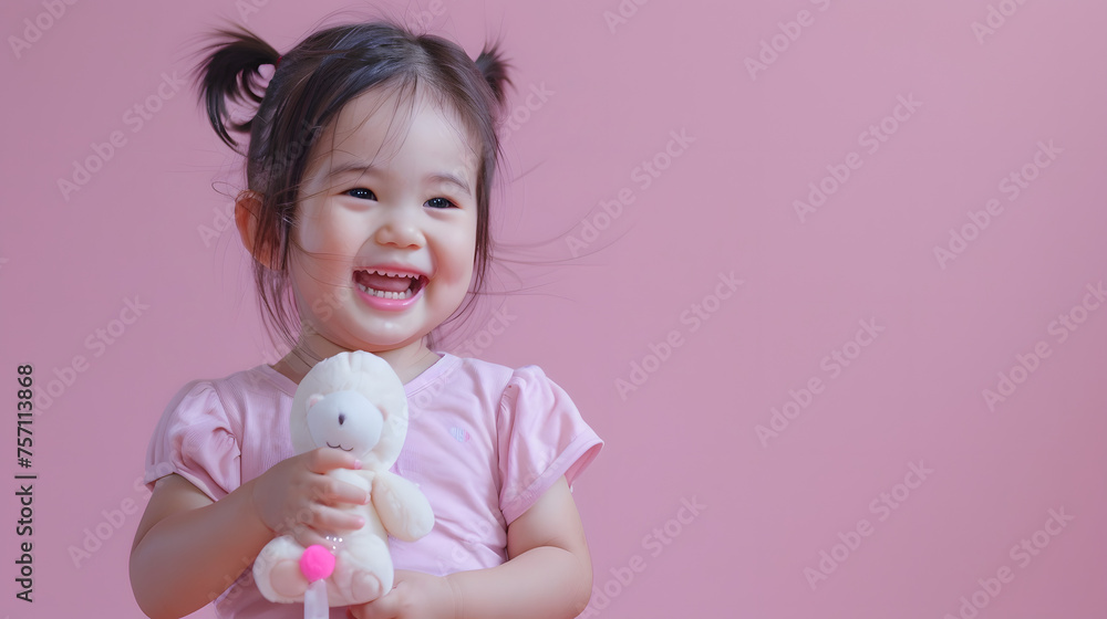 Adorable little indonesian three-year-old girl in pink short sleeves,holding a mini plush, Adorable little indonesian three-year-old girl in pink short sleeves,holding a mini plush,