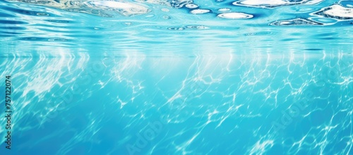 A close up of a sparkling swimming pool filled with liquid water and bubbles rising to the surface creating a beautiful display of electric blue in the sky, perfect for leisure and recreation