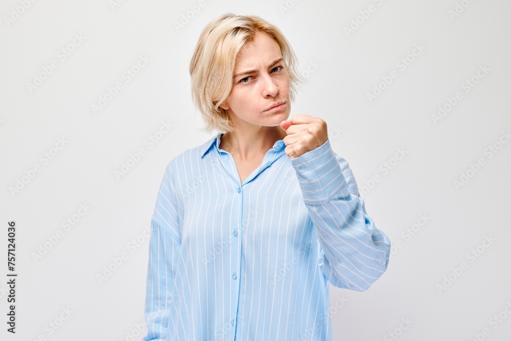 Angry woman yelling with clenched fists on white background expressing frustration or strong emotion Angry woman yelling with clenched fists on white background expressing frustration or strong emotion