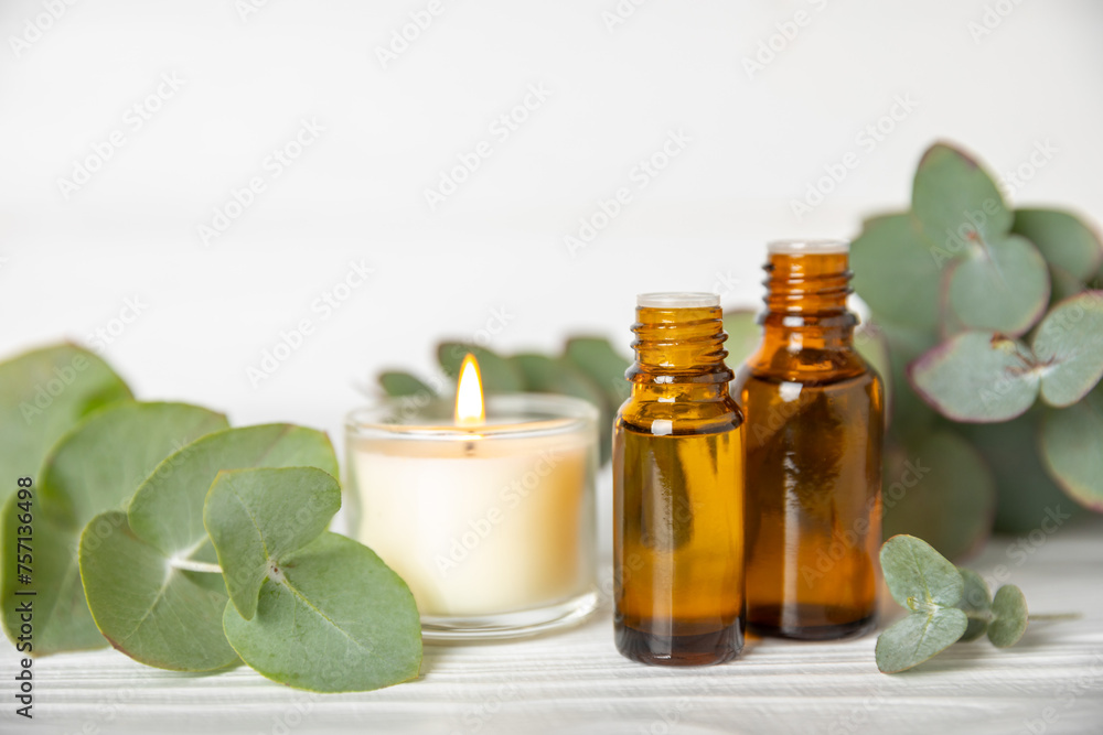 Eucalyptus essential oil in a glass bottle with green eucalyptus leaves on a textured wooden background. Aromatherapy concept. Spa. Natural organic ingredients for cosmetics and body care.Copy space Eucalyptus essential oil in a glass bottle with green eucalyptus leaves on a textured wooden background. Aromatherapy concept. Spa. Natural organic ingredients for cosmetics and body care.Copy space