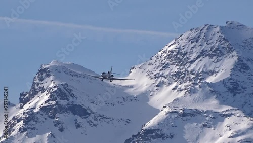 private jet high end luxury vip money rich flying final approach for landing snow covered mountain winter landscape background airplane photo