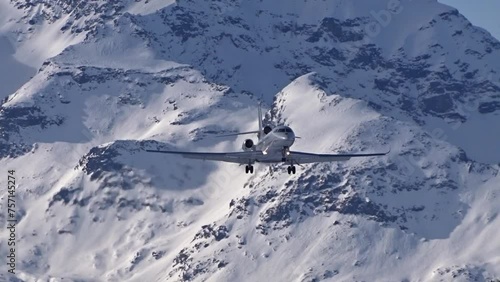business jet flying final approach for landing at snow covered airport generic unmarked winter background landscape scenic close up