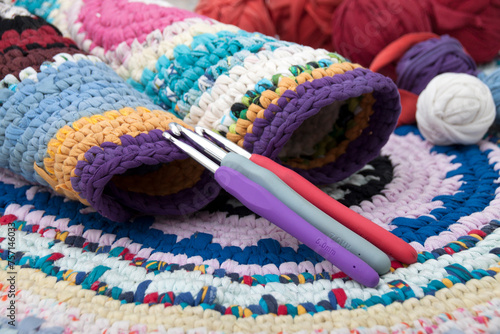 Colored rugs in rustic style, balls and crochet hooks