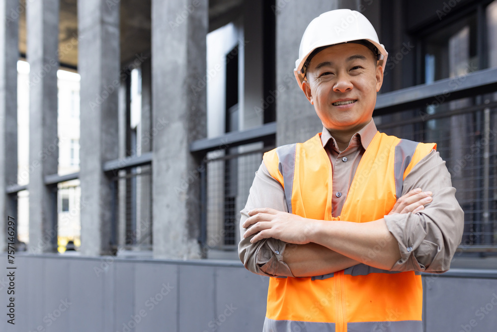 Confident construction worker smiling at a building site Confident construction worker smiling at a building site