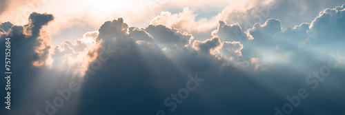 Beautiful sky background with clouds and sunbeams. Dramatic cloudscape with sun rays. Bright sunshine and sunny glow. Wide panoramic background for design. © Andrei Stepanov