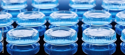 A stack of azure plastic water bottles arranged in a circle on a table  forming a fluid composition of electric blue hues resembling a liquid font