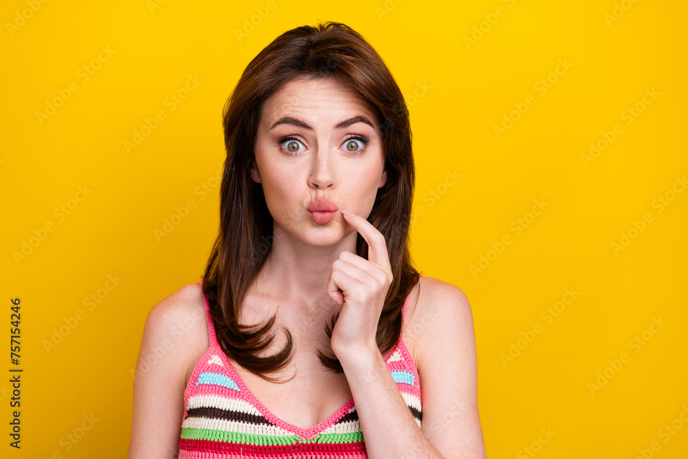 Portrait of funny flirty minded woman with piercing wear knit tank finger on pouted lips staring isolated on vivid yellow color background Portrait of funny flirty minded woman with piercing wear knit tank finger on pouted lips staring isolated on vivid yellow color background