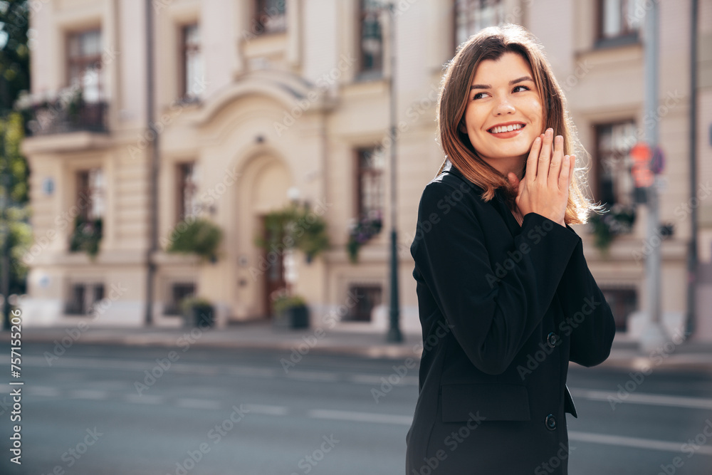 Portrait of young beautiful brunette woman wearing nice trendy suit black jacket clothes. Sexy smiling model posing in the street at sunny day. Fashionable female outdoors. Cheerful and happy