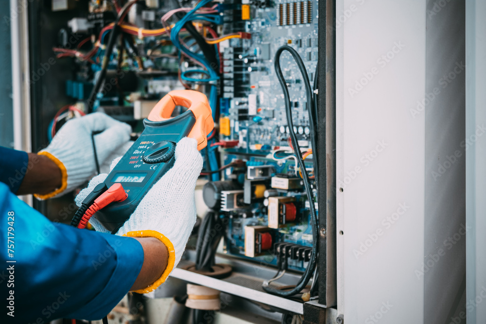 Technician is checking air conditioner refrigerant system maintenance and check switch board control Technician is checking air conditioner refrigerant system maintenance and check switch board control