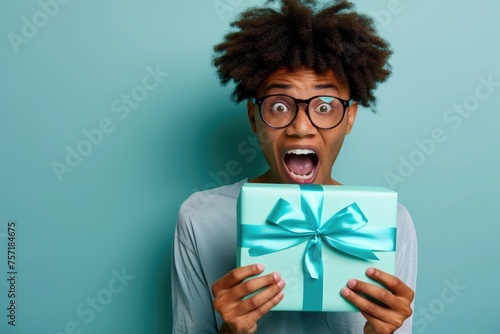 A man with a startled expression on his face holds a gift in his hands, expressing shock and surprise, A person opening a gift with surprise and excitement, AI Generated © Iftikhar alam